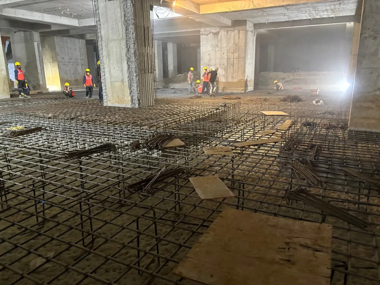 Dense reinforcement mat across a basement floor before concreting